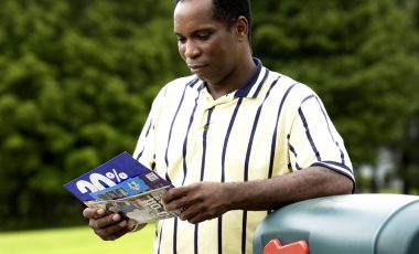 African American man getting mail from mailbox