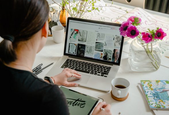 woman designing flyer on laptop